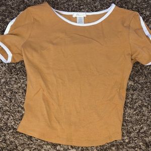 A stylist tan color crop top with white on sleeves and neck line